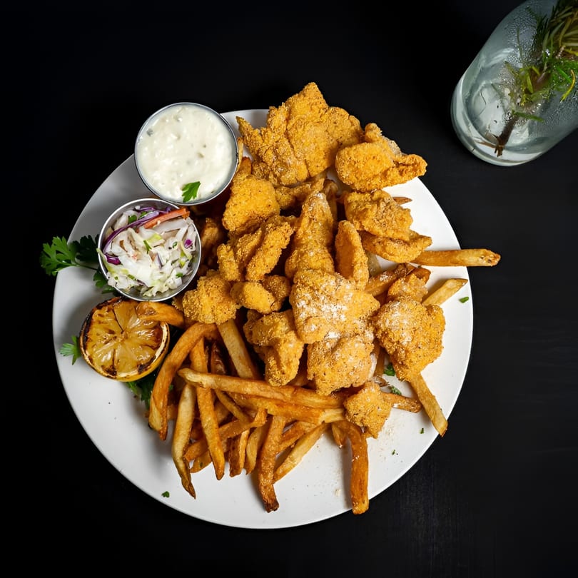 McClellan’s Fish and Chicken's fried fish and french fries, with coleslaw, tartar sauce, and a grilled lemon.
