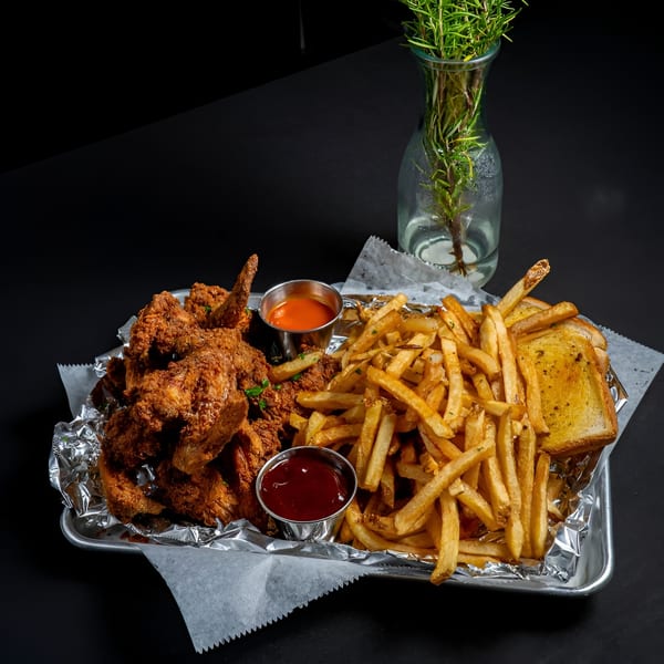 A tray of McClellan's fried chicken, french fries, garlic toast, and two dipping sauces.